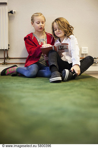 Cute little girl and boy reading book