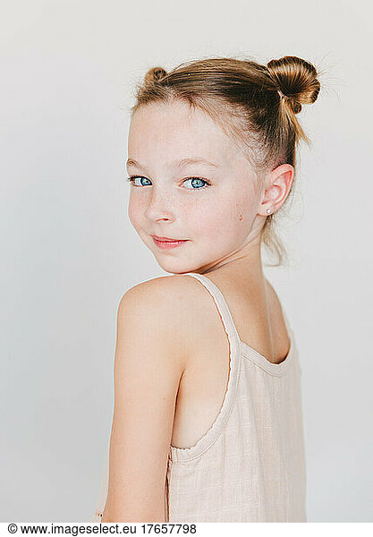 cute little girl looking over her shoulder  white background