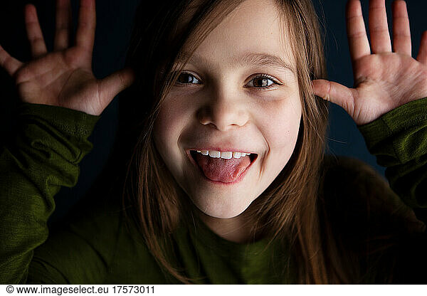 cute smiling little 9 year old girl showing her tongue