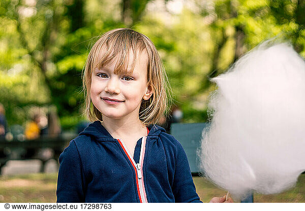 Cute young girl 3-4 years old eating cotton candy