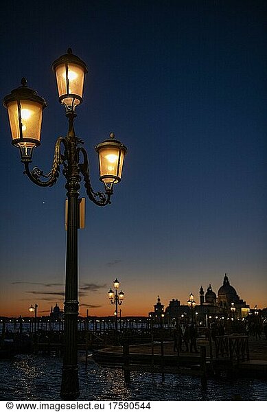 Düstere Stimmung  Beleuchtete Laterne zur blauen Stunde  Kirche Santa Maria della Salute im Hintergrund  Venedig  Venetien  Italien  Europa