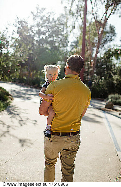 Dad Carrying Toddler Daughter in Garden in California