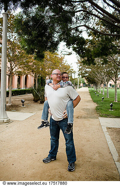 Dad Giving Ten Year Old Son a Piggyback Ride in San Diego