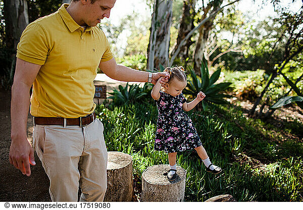 Dad Holding Daughter's Hand in Garden in California
