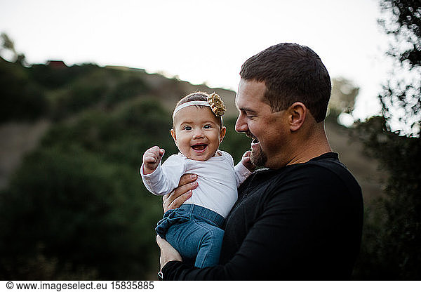 Dad Holding Infant Daughter as Baby Smiles