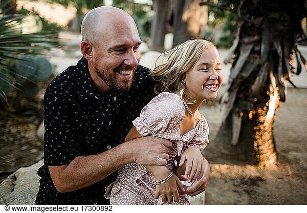 Dad Tickling Daughter in Garden in San Diego
