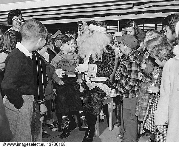 Daly City  California: c. 1955 A gaggle of grade school children flock around Santa Claus.