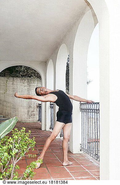 Dancer practicing by railing on porch