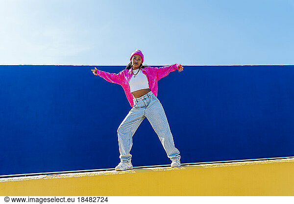 Dancer with cool attitude dancing in front of blue wall