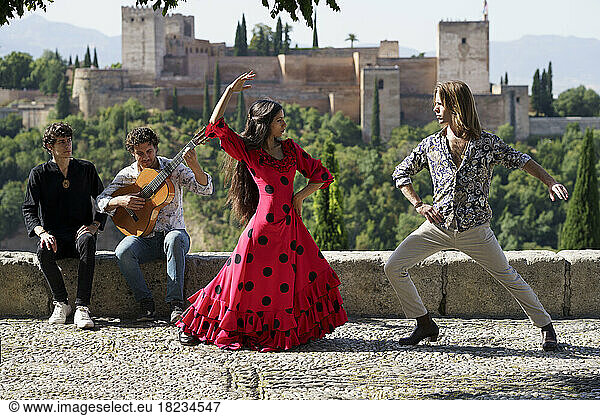 Dancers and musician performing flamenco on sunny day in front of Alhambra  Granada  Spain