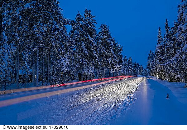 Dangerous road conditions  driving a car at night on icy snow covered winter road in the Arctic Circle in Lapland  Finland