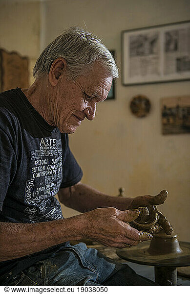 Daniel 'Chichi' Santander  renowned Cuban potter  works on pottery that he has making at El Alfarereo Casa Chichi  Trinidad  Sancti Spiritus  Cuba