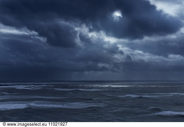 Dark clouds in overcast sky over stormy ocean  Devon  United Kingdom
