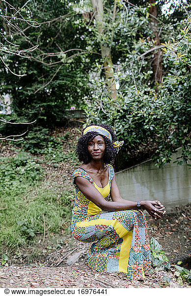 Dark skinned woman wearing african head band colorful dress outdoor