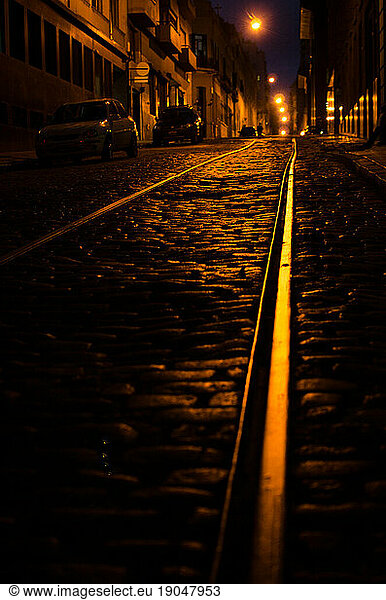 Dark street at night with abandoned train rails
