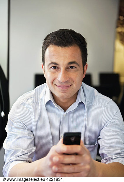 Darkhaired man in shirt with mobile