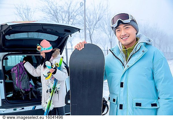 Das Auto nach jungen Begleiter mit Skiern