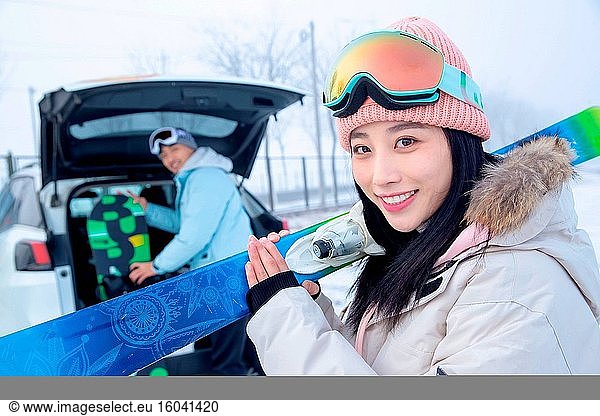 Das junge Paar hinter dem Auto mit den Skiern