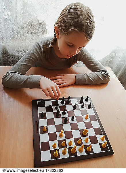 das Mädchen denkt beim Schachspielen nach