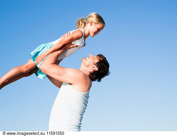 daughter and father playing on beach