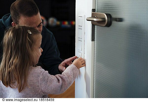 Daughter with father adjusting temperature at home