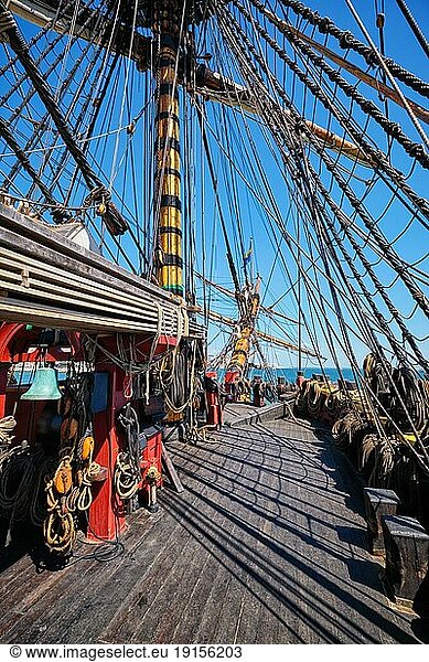 Deck mit Masten und Seilen und Buggeist eines hölzernen Segelschiffs aus der Zeit der Segel