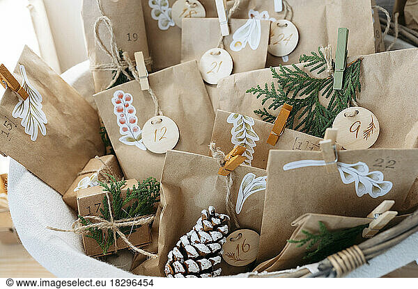 Decorated brown bags with gift boxes and pine cones kept in basket