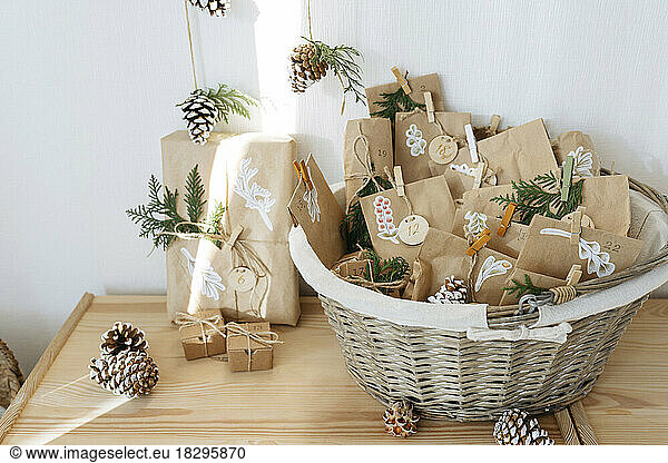 Decorated brown paper bags kept in basket for DIY advent calendar