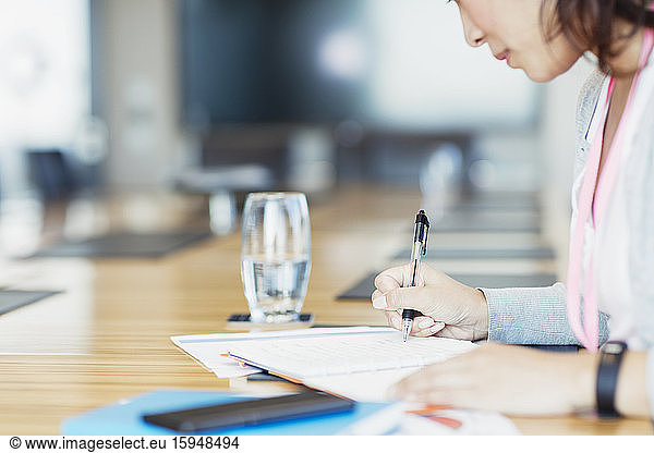 Dedicated businesswoman with paperwork in conference room