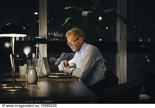 Dedicated senior male professional working late at creative workplace