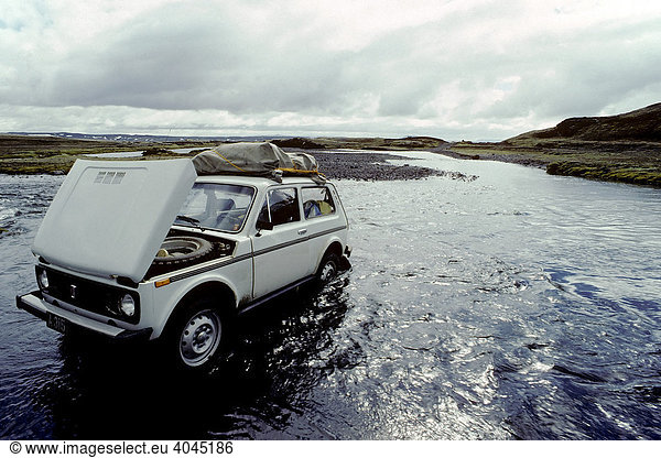 Defektes Geländefahrzeug steht mit offener Kühlerhaube in einem Gletscherfluss  in Furt stecken geblieben  Island  Europa