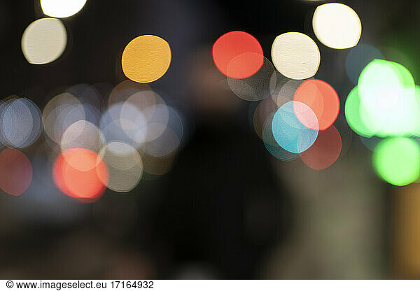 Defocused image of multi colored illuminated lights in city at night