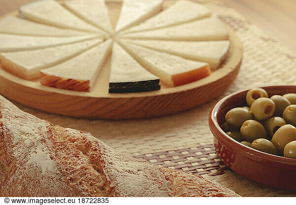 Delicious cheese board with rustic bread and olives