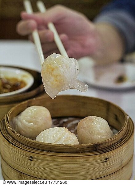 Delicious Chinese dim sum in a chinese restaurant  chopsticks holding steamed shrimp roll