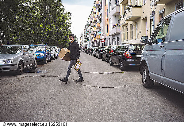 Delivery man with package walking on street in city