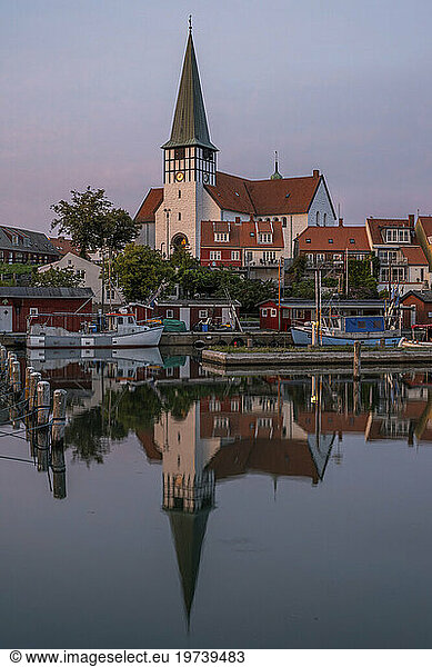 Denmark  Bornholm  Ronne  St Nicholas Church reflecting in coastal water at dusk