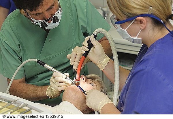 Dentist and an assistant with a patient during dental treatment