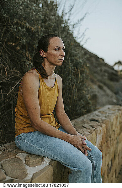 Depressed woman sitting on wall
