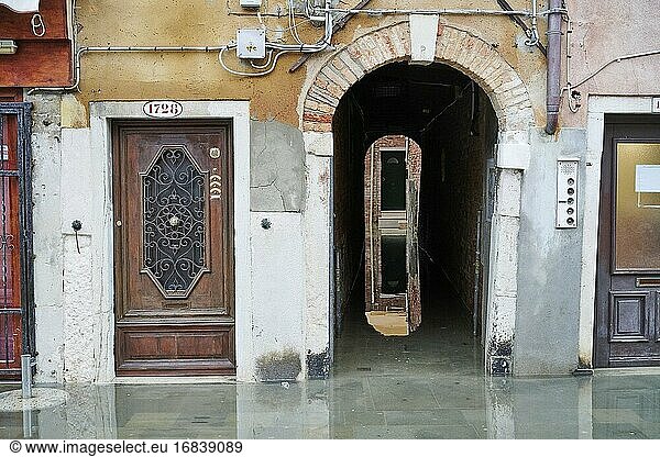 Der Eingang eines Wohnhauses in der Giuseppe-Garibaldi-Straße während der Flut  die hier als acqua alta bezeichnet wird. Das Castello-Viertel. Venedig. Italien.