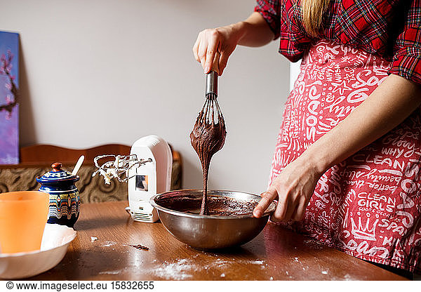 Der Prozess des Mischens und Zubereitens von Schokoladenkuchen durch eine junge Dame