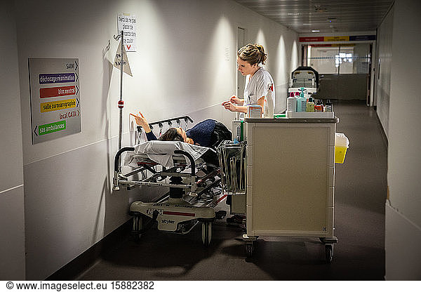 Des infirmiers prennent en charge un patient placé dans un brancard.