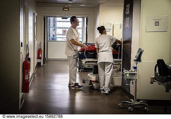 Des infirmiers prennent en charge un patient placé dans un brancard.
