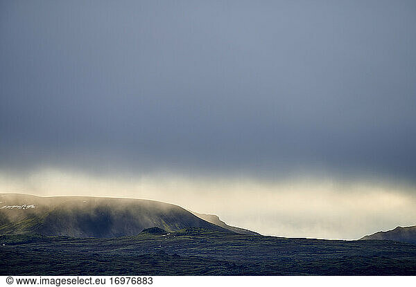 Desert hilly terrain under fog and blue sky
