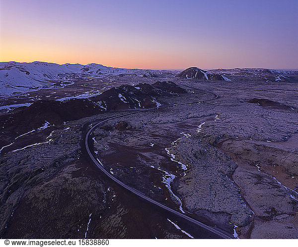 Desert road in rocky terrain during sundown