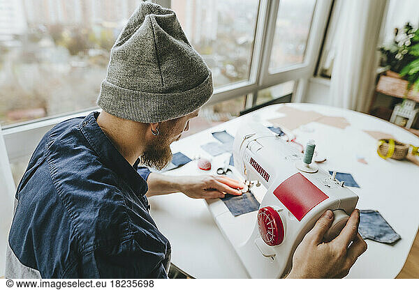 Design professional working on sewing machine in workshop