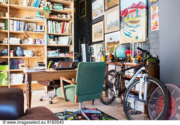 Desk  bookshelves and bicycle in study