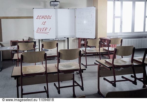 Desks and chairs in empty classroom  Bavaria  Germany