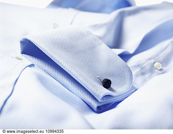 Detail of cuff of blue shirt in studio