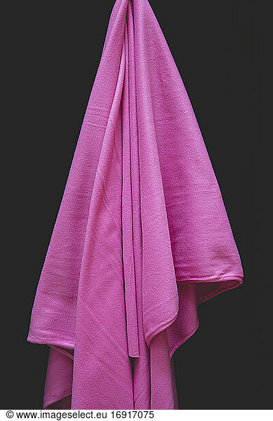 Detail of draped pink fleece fabric against black background
