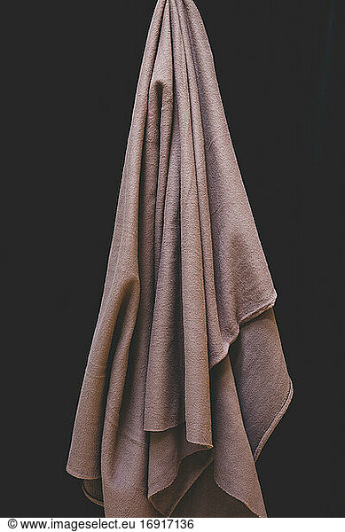 Detail of hanging fleece fabric against black backdrop